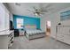 Spacious main bedroom featuring a large window, turquoise accent wall, and ceiling fan at 7821 Mazarine St, North Las Vegas, NV 89084