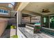 Outdoor kitchen with built in grill, tile countertop and ceiling fan at 7821 Mazarine St, North Las Vegas, NV 89084