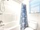 Bright bathroom featuring a tub/shower with a blue patterned curtain, toilet, and clean white tile at 8120 Backpacker Ct, Las Vegas, NV 89131