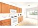 Inviting kitchen with wood cabinetry, white appliances, and ample counter space, ideal for meal preparation at 8120 Backpacker Ct, Las Vegas, NV 89131