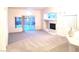 Bright living room with plush carpeting, fireplace, and sliding glass door to backyard at 8120 Backpacker Ct, Las Vegas, NV 89131