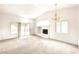 Spacious living room with carpet, fireplace, large windows, and chandelier that create a cozy atmosphere at 8120 Backpacker Ct, Las Vegas, NV 89131