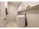 Laundry room with tile flooring, washer and dryer, storage cabinets and shelving at 8180 Loma Del Ray St, Las Vegas, NV 89131
