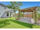 A charming backyard boasting a custom pergola, manicured lawn, and a cozy patio, perfect for outdoor entertaining at 8349 Pollenzo Ave, Las Vegas, NV 89178