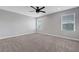 Carpeted bedroom with natural light, ceiling fan, and neutral colored walls at 8349 Pollenzo Ave, Las Vegas, NV 89178