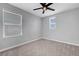 Bedroom with neutral carpet, ceiling fan and two large windows at 8349 Pollenzo Ave, Las Vegas, NV 89178