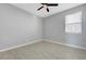 A bedroom with wood-look floors, a ceiling fan, and a window for natural light at 8349 Pollenzo Ave, Las Vegas, NV 89178