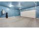 A spacious garage featuring painted walls, epoxy floor, and modern lighting, ready for vehicles and storage at 8349 Pollenzo Ave, Las Vegas, NV 89178