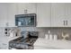 Updated kitchen featuring a gas range, built-in microwave, and white cabinetry at 8349 Pollenzo Ave, Las Vegas, NV 89178