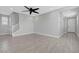 Spacious living room with grey wood-look flooring and a modern ceiling fan at 8349 Pollenzo Ave, Las Vegas, NV 89178