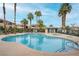 Community pool with palm trees and lounge chairs, offering a relaxing outdoor space at 8410 Eldora Ave # 2082, Las Vegas, NV 89117