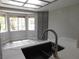 Modern kitchen showcasing a sink with views from the window, quartz countertops, and gray cabinets at 8640 Portofino Ct, Las Vegas, NV 89117