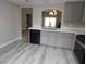 Open-concept kitchen features quartz counters, stainless steel appliances, gray cabinets and laminate floors at 8640 Portofino Ct, Las Vegas, NV 89117