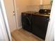 Modern black washer and dryer set in a laundry room with wood-style flooring at 8640 Portofino Ct, Las Vegas, NV 89117