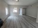Open-concept living room with modern light fixture and wood-look flooring, leading to kitchen at 8640 Portofino Ct, Las Vegas, NV 89117