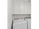 Bright laundry room with overhead cabinets and full size machines at 884 Adobe Flat Dr, Henderson, NV 89011