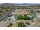Wide-angle shot showcasing lot with desert landscaping and sparse trees in a neighborhood near a highway with mountain views at 8970 W Lone Mountain Rd, Las Vegas, NV 89129