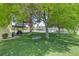 Serene backyard featuring a tree swing, green lawn, covered outdoor seating area, and mature shade trees at 8970 W Lone Mountain Rd, Las Vegas, NV 89129