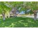 Beautiful backyard featuring mature trees, well-manicured lawn, and a covered patio with an outdoor dining set at 8970 W Lone Mountain Rd, Las Vegas, NV 89129