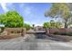View of the landscaped front entrance featuring a decorative brick wall and iron gate at 8970 W Lone Mountain Rd, Las Vegas, NV 89129