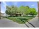 Charming single-story home with a lush, green front yard and mature trees providing shade and character at 8970 W Lone Mountain Rd, Las Vegas, NV 89129