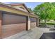 Spacious three-car garage with brown doors provides ample parking and storage, complementing the house's exterior at 8970 W Lone Mountain Rd, Las Vegas, NV 89129