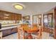 Bright eat-in kitchen with dark wood cabinets and breakfast bar open to the living area at 8970 W Lone Mountain Rd, Las Vegas, NV 89129