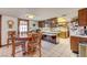 Eat-in kitchen with custom wood cabinets, tiled floors, and plenty of counter space at 8970 W Lone Mountain Rd, Las Vegas, NV 89129