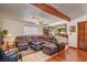Comfortable living room featuring a large sectional sofa, wooden beam, and seamless access to other rooms at 8970 W Lone Mountain Rd, Las Vegas, NV 89129