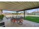 Covered patio with seating, offers an inviting space for outdoor relaxation and entertaining, with views of the yard at 8970 W Lone Mountain Rd, Las Vegas, NV 89129