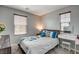 Bedroom featuring a desk, two windows with blinds, and a bed with decorative pillows at 900 Harbor Ave, Henderson, NV 89002