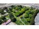 Aerial view of a green park featuring pathways, mature trees, open lawn, and recreational buildings at 9052 Pine Mission Ave, Las Vegas, NV 89143