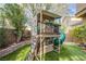 A custom playhouse with slide and climbing ladder sits atop manicured synthetic turf at 9052 Pine Mission Ave, Las Vegas, NV 89143