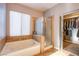 Inviting bathroom featuring a soaking tub, glass shower, and tile flooring at 9052 Pine Mission Ave, Las Vegas, NV 89143