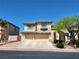 Charming two-story home with a balcony, a two-car garage, and well-maintained landscaping under a clear sky at 9052 Pine Mission Ave, Las Vegas, NV 89143