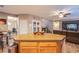 Open kitchen with an island bar extends into a cozy Gathering room with fireplace and TV at 9052 Pine Mission Ave, Las Vegas, NV 89143