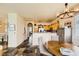 Open-concept kitchen with light wood cabinets, stone floors, and breakfast bar at 10798 Muscari Way, Las Vegas, NV 89141