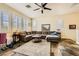 Comfortable living room with a ceiling fan, tile flooring, and large windows at 10798 Muscari Way, Las Vegas, NV 89141