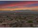 Panoramic aerial view of a residential area with city lights and mountain silhouettes during twilight at 1124 Whistle Ct, Henderson, NV 89011