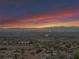 Expansive aerial shot capturing the residential area, distant mountains, and vibrant sky at dusk at 1124 Whistle Ct, Henderson, NV 89011