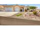 Charming single-story home with well-manicured front yard, three-car garage, and desert landscaping at 1124 Whistle Ct, Henderson, NV 89011