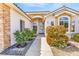 Charming home entrance featuring double doors, stone accents, and colorful mature landscaping at 1124 Whistle Ct, Henderson, NV 89011