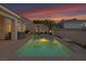 Inviting backyard pool area with a seating area, lush landscaping, and relaxing ambiance at twilight at 1124 Whistle Ct, Henderson, NV 89011