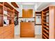 Bright, well-organized walk-in closet featuring custom wood shelving, drawers, and ample storage space at 1124 Whistle Ct, Henderson, NV 89011