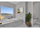 Bathroom features a soaking tub, large window, tile surround, modern fixtures, and separate toilet area at 2805 Proust Ct, Henderson, NV 89044
