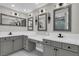 Dual sink vanity in a bathroom featuring modern fixtures, framed mirrors, and tiled shower at 2805 Proust Ct, Henderson, NV 89044
