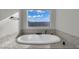 Soaking tub offers views from the window and sits atop a tile base at 2805 Proust Ct, Henderson, NV 89044