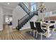 Dining room with staircase and large window; modern chandelier, hardwood floors, and neutral color palette at 2805 Proust Ct, Henderson, NV 89044