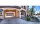 Elegant exterior elevation featuring an arched porte-cochère, manicured landscaping, and a charming front porch at 2805 Proust Ct, Henderson, NV 89044