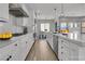 Modern kitchen with white cabinetry, stainless steel appliances, pendant lighting, and spacious quartz countertops at 2805 Proust Ct, Henderson, NV 89044